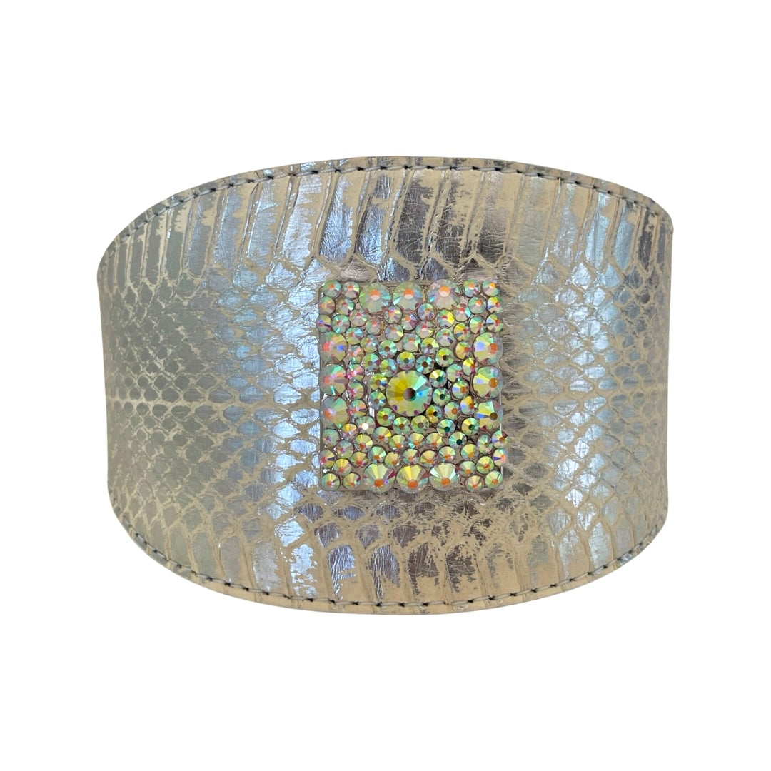 Curved silver-toned cuff bracelet with snakeskin texture and a central square cluster of iridescent Swarovski crystal rivets.