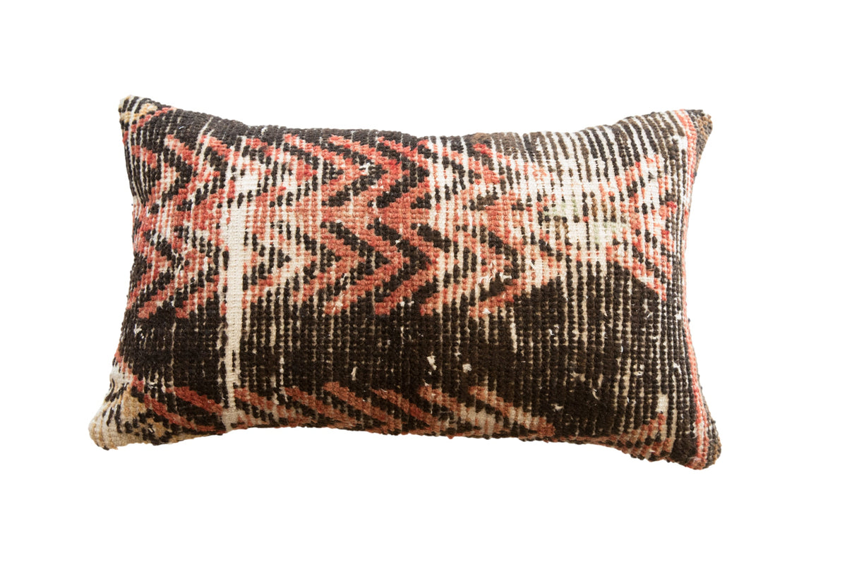 Vintage Rug Fragment Pillow featuring worn textile patterns in muted reds and beiges on rectangular shape