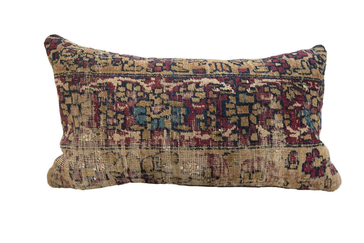 Vintage Rug Fragment Pillow with geometric pattern in red, blue, cream, and rust tones on a neutral backdrop
