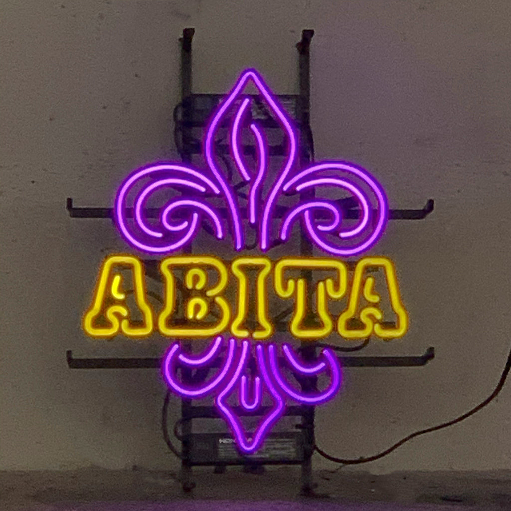 Abita Neon Sign glowing in an indoor setting, mounted on metal grid backing