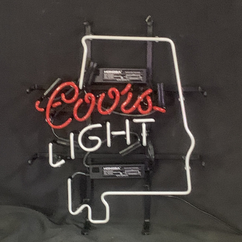 Neon light sign featuring red cursive text 'Coors' inside a white outline of the state of Alabama, with 'LIGHT' in white block letters below.