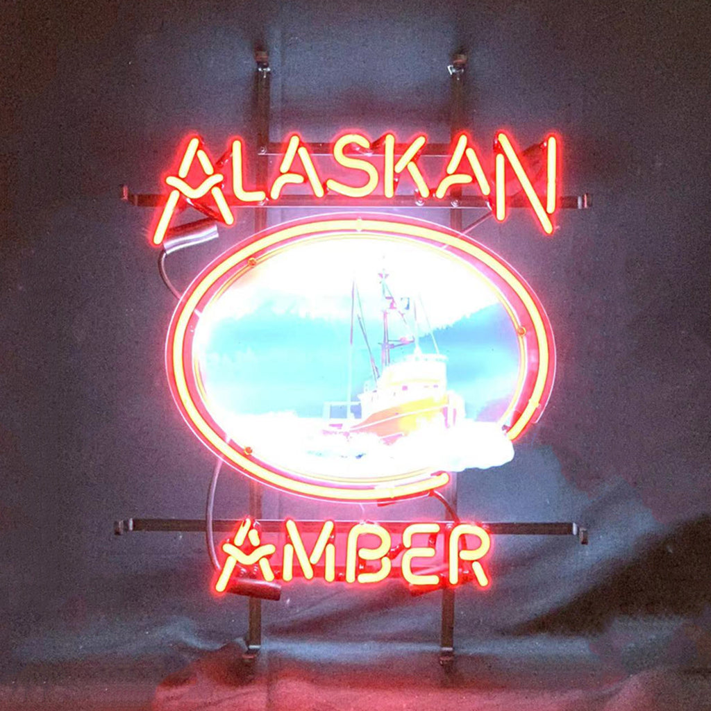 Red neon sign with the words 'ALASKAN AMBER' surrounding a central circular image of a boat against a blue sky background.