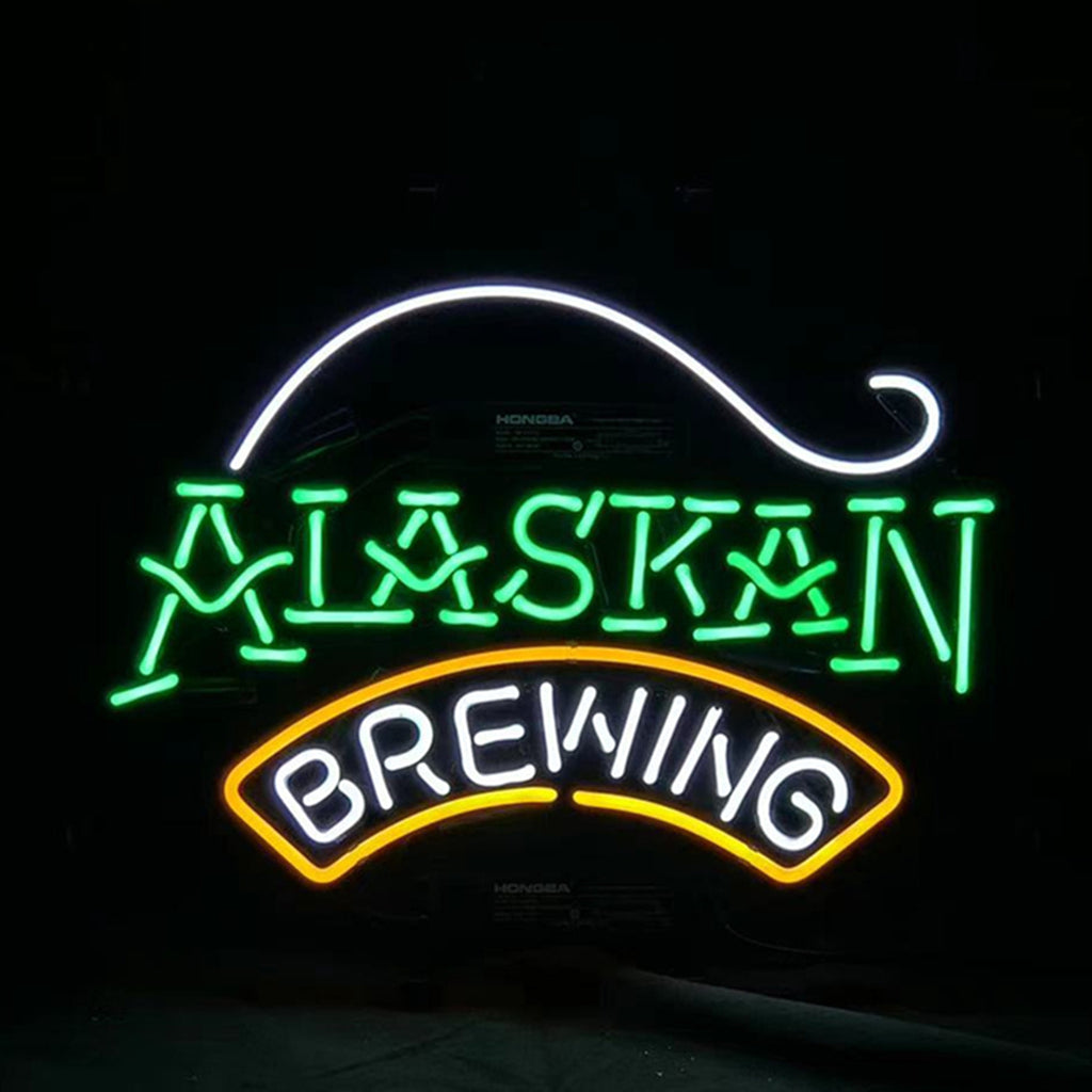 Neon sign with 'Alaskan' in green and 'Brewing' in white letters outlined by an orange arch beneath a white curved line.