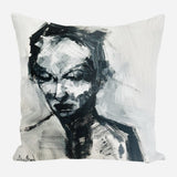 Abstract black and white brushstroke portrait of a person with downward gaze on a square pillow with textured paint effects.