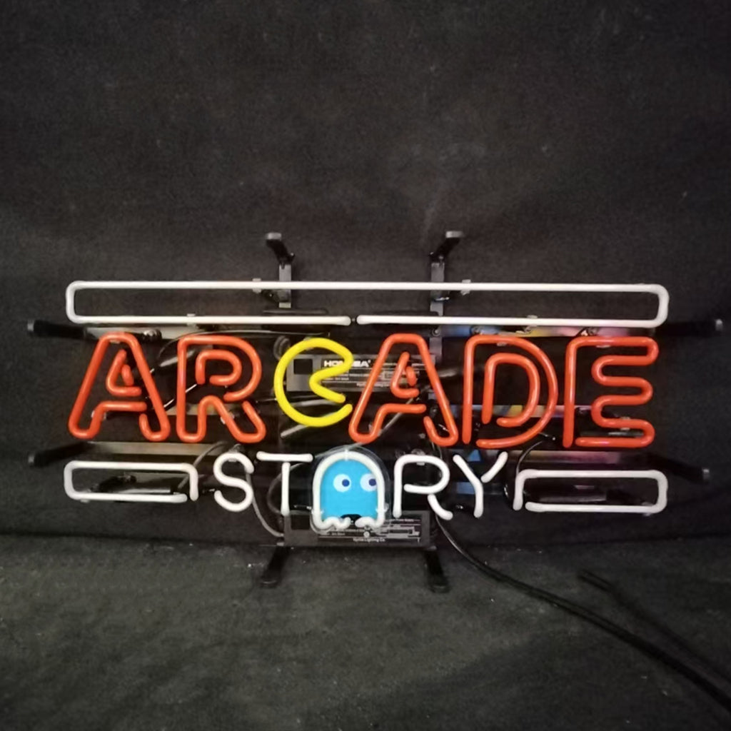 Neon sign with red letters spelling ARCADE, a yellow Pac-Man replacing the letter C, white letters spelling STORY below, and a blue ghost figure beneath the text