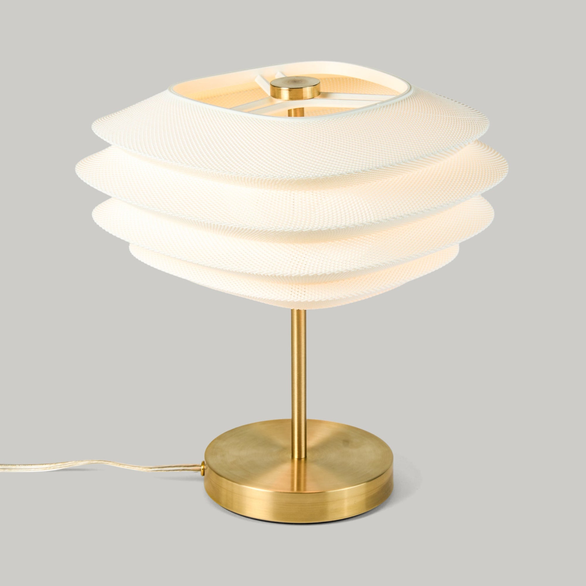 Arcas Lamp by Wooj Design showing a table lamp with complex 3D printed shade and Brass base