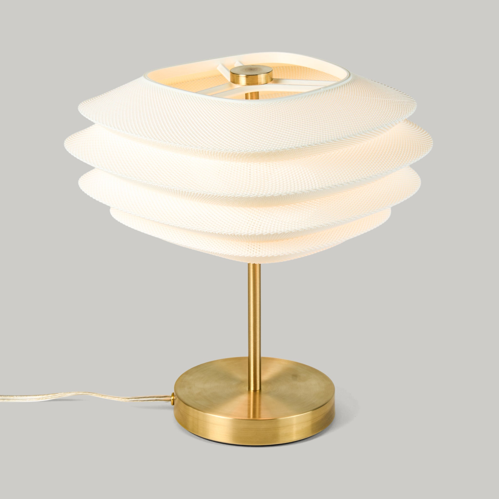 Arcas Lamp by Wooj Design showing a table lamp with complex 3D printed shade and Brass base