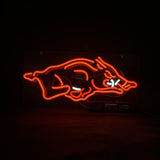 Red neon light shaped as a stylized wild hog with white neon accents depicting eyes and tusks on a black background.