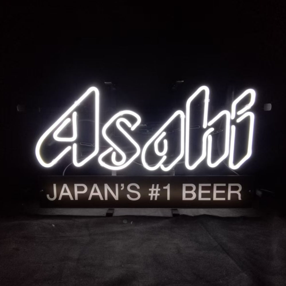 White neon sign displaying the word 'Asahi' above a black panel with white text reading 'JAPAN'S #1 BEER' against a dark background