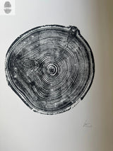 Black ink woodcut print of an aspen tree cross section showing detailed growth rings on white paper, signed in pencil at the bottom right.