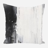 Square pillow with abstract black and white vertical brushstroke design blending dark charcoal and light gray tones