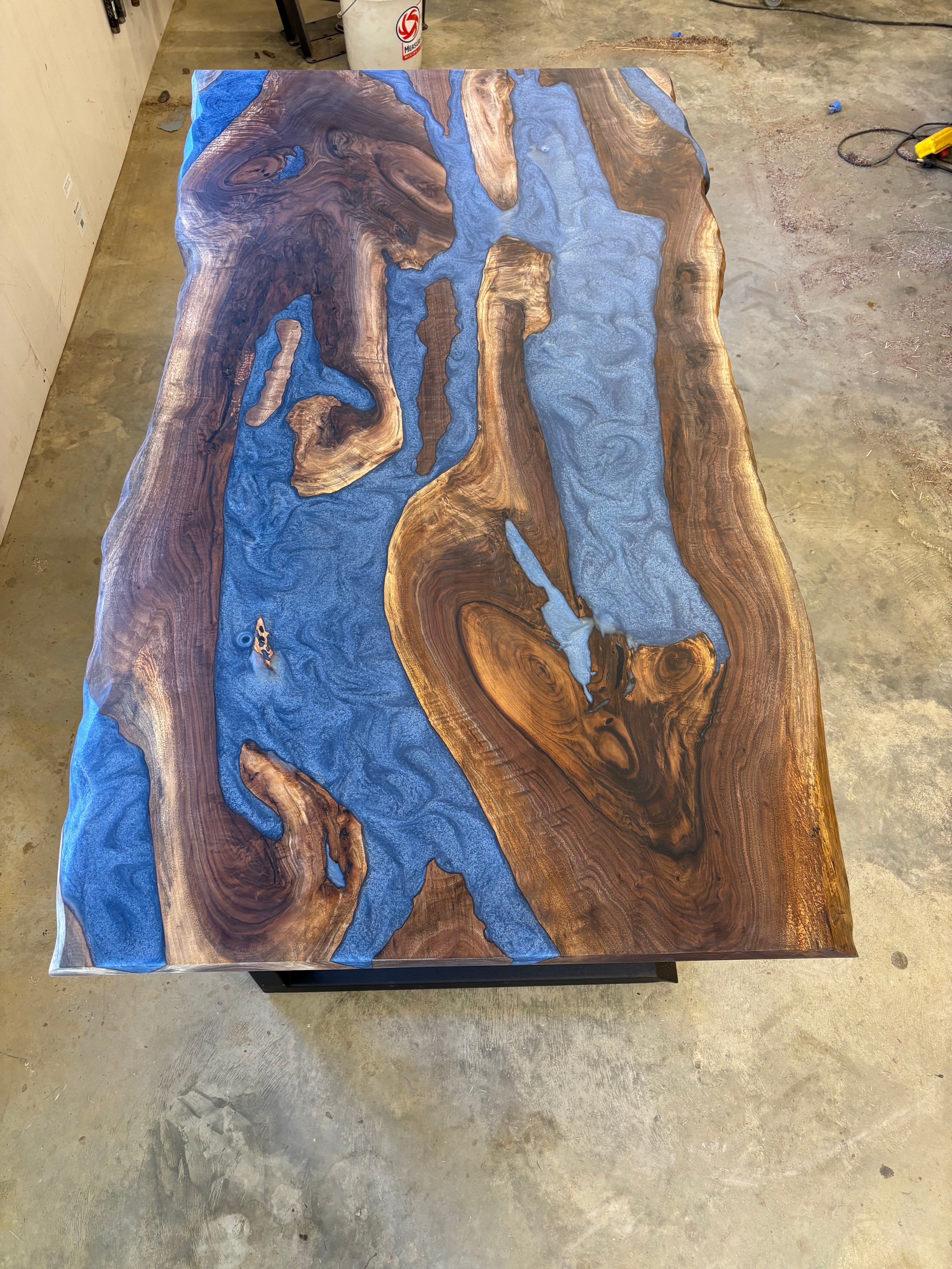 6x3 walnut river table with blue resin inlay in a workshop setting