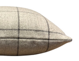 Close-up of a beige wool pillow cover with a Malt Brown large check pattern and a pointed edge seam detail.