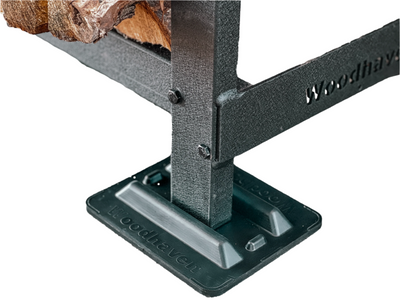 Black and brown firewood rack support bases stacked on concrete and grass surfaces