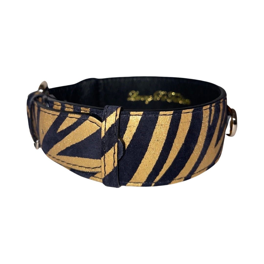 Wide dog collar with black and gold zebra print pattern made of leather, featuring metallic ring attachments on each side.