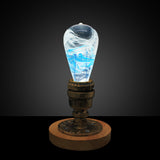EP Light Blue-Drop Resin LED Bulb handcrafted with eco-friendly resin, shown with wooden base options
