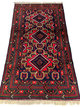 Rectangular hand-knotted Afghani Baluch wool rug with three large diamond medallions in navy, red, and beige, surrounded by geometric borders and fringed ends.