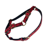 Red and black leopard print leather harness with gold-tone rectangular buckles and metal ring hardware, featuring adjustable straps.
