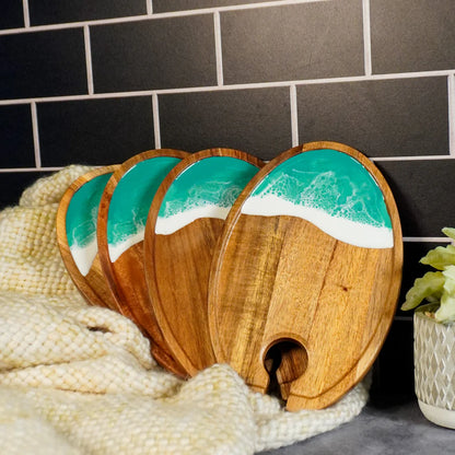 Set of wooden resin Wine & Appetizer Trays with ocean design against a tiled wall.