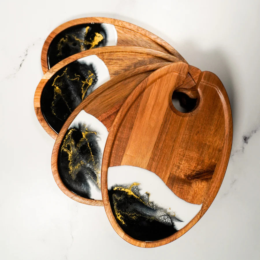 Wooden resin Wine & Appetizer Trays  with black, white, and gold marbled designs on a marble surface.