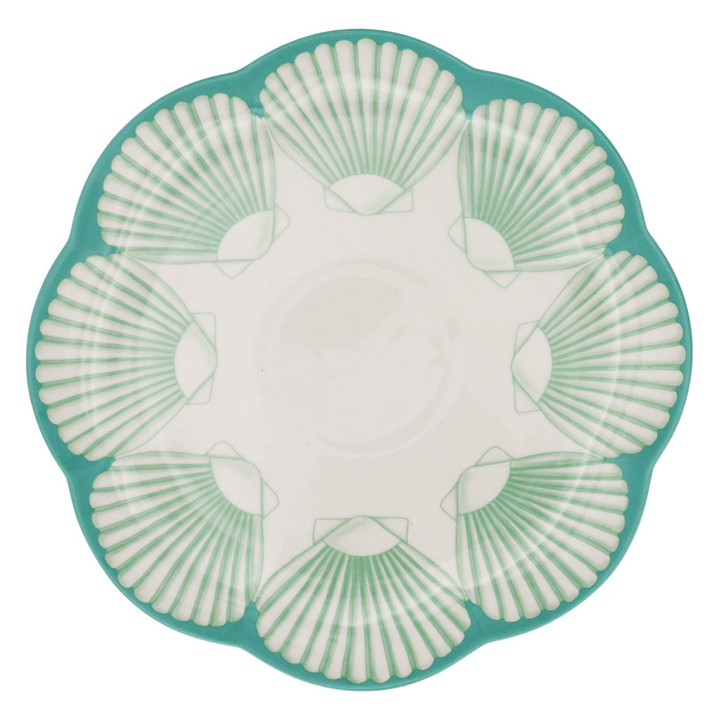 Set of Balearic Blu dinner plates with scalloped edges and sea-blue shell design, arranged on a table.