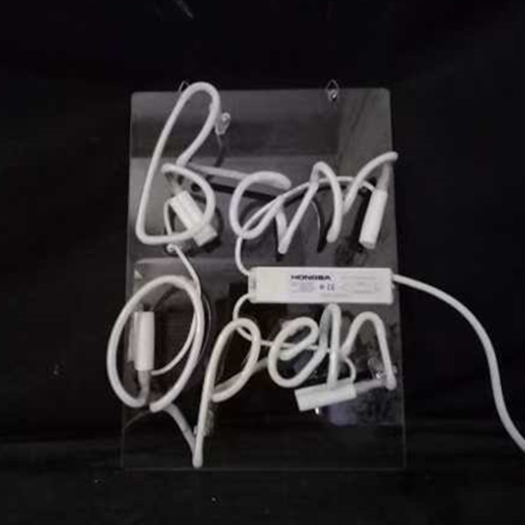 White neon light tubing spelling 'Bar Open' mounted on a clear rectangular backing with visible power cords and components, against a black background.