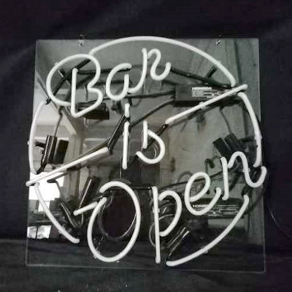 White neon sign reading 'Bar is Open' within a circular border, mounted on a reflective black backing, showing electrical components and wires.