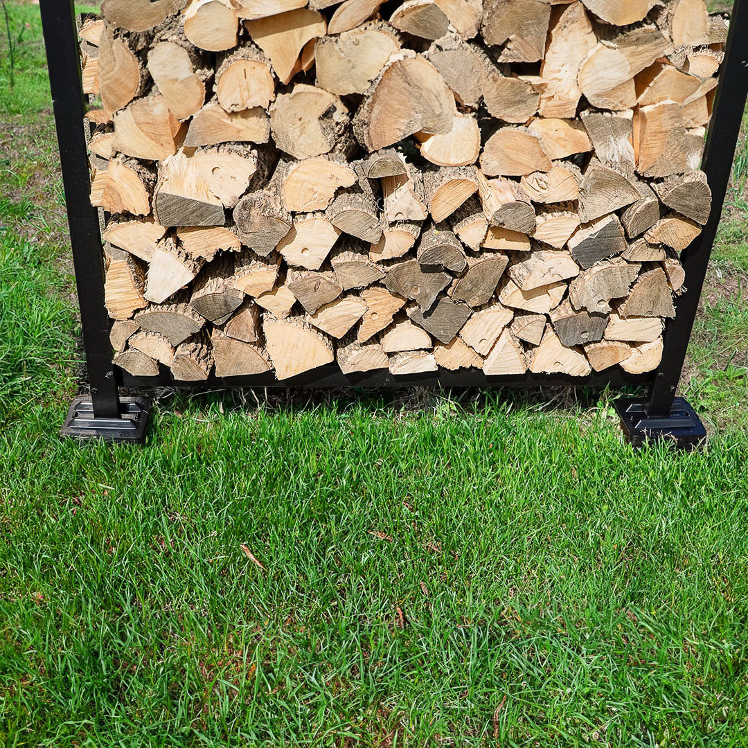 Black and brown firewood rack support bases stacked on concrete and grass surfaces