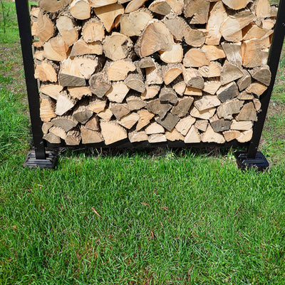 Black and brown firewood rack support bases stacked on concrete and grass surfaces