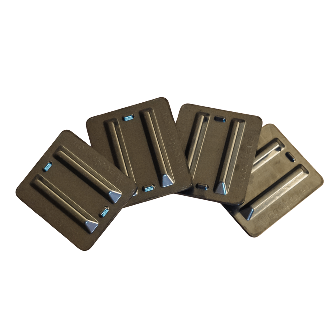 Black and brown firewood rack support bases stacked on concrete and grass surfaces