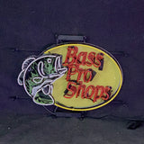 Oval neon sign with yellow background featuring a green bass fish outline and red 'Bass Pro Shops' text in the center, mounted on a black frame.