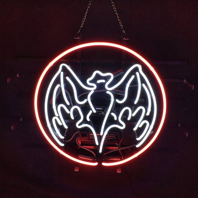 Bat-shaped neon sign glowing orange mounted against a dark background