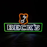 Neon light sign with bold white text 'BECK'S' inside a green rectangular outline topped by an orange shield shape with white letters 'G' and 'H'.