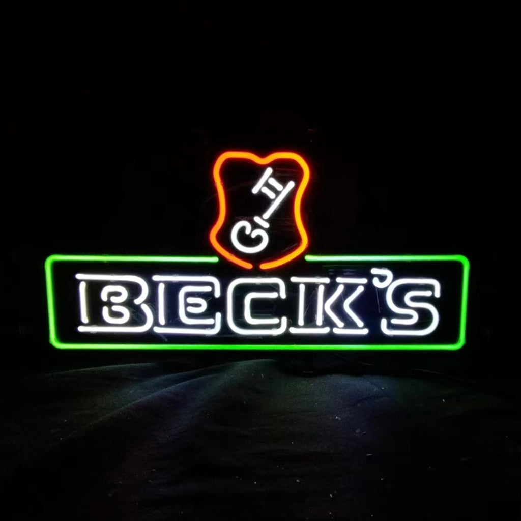 Neon light sign with bold white text 'BECK'S' inside a green rectangular outline topped by an orange shield shape with white letters 'G' and 'H'.