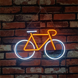 Neon sign shaped like a bicycle with bright orange frame and white wheels, mounted on a red and white brick wall background.