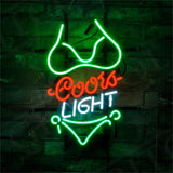 Neon sign shaped like a green bikini with 'Coors' in red cursive and 'LIGHT' in white block letters on a dark brick wall.
