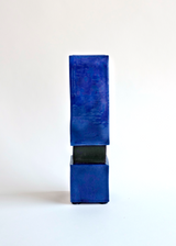 Tall rectangular blue ceramic vase with a narrow black base, displayed against a white background.