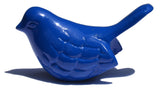 Glossy blue bird figurine with detailed feather carvings and a slightly raised tail casting a shadow on white background.