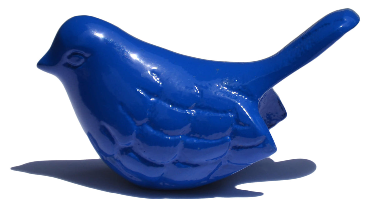Glossy blue bird figurine with detailed feather carvings and a slightly raised tail casting a shadow on white background.