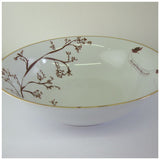 White ceramic serving bowl with delicate brown tree branch design and small bird on rim, featuring a thin gold edge around the rim.
