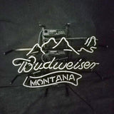 White neon light sign with a mountain outline above cursive 'Budweiser' and block letters spelling 'Montana' beneath on a dark background