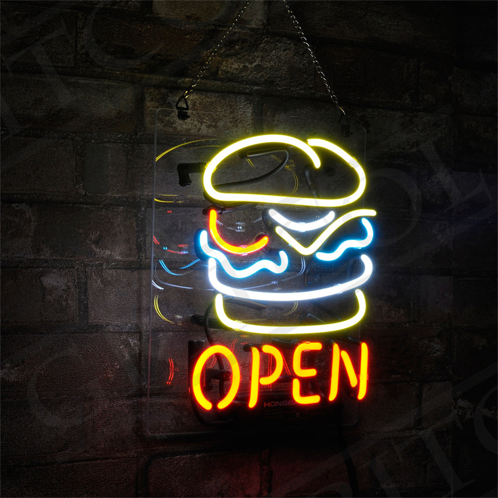 Neon sign of a stylized burger outlined in yellow, white, and blue neon tubes above the word OPEN in red neon, mounted on a dark brick wall and hanging by chains.