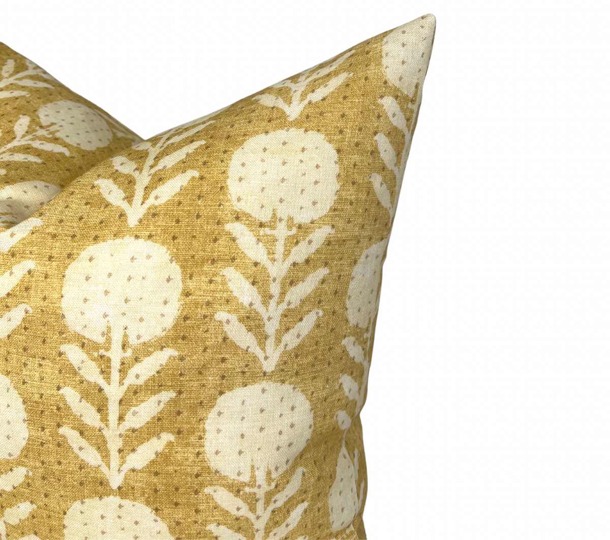 Close-up of a goldenrod pillow cover with a repeating pattern of stylized, off-white zinnia flowers and leaves on textured fabric.