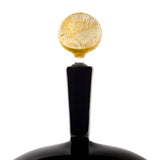 Glass bottle stopper with a round, amber-yellow top featuring textured, organic patterns, and a sleek, smooth black handle extending downward.