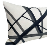 Rectangular white pillow with an abstract pattern of intersecting black and gray inspired brushstroke lines creating a geometric design.