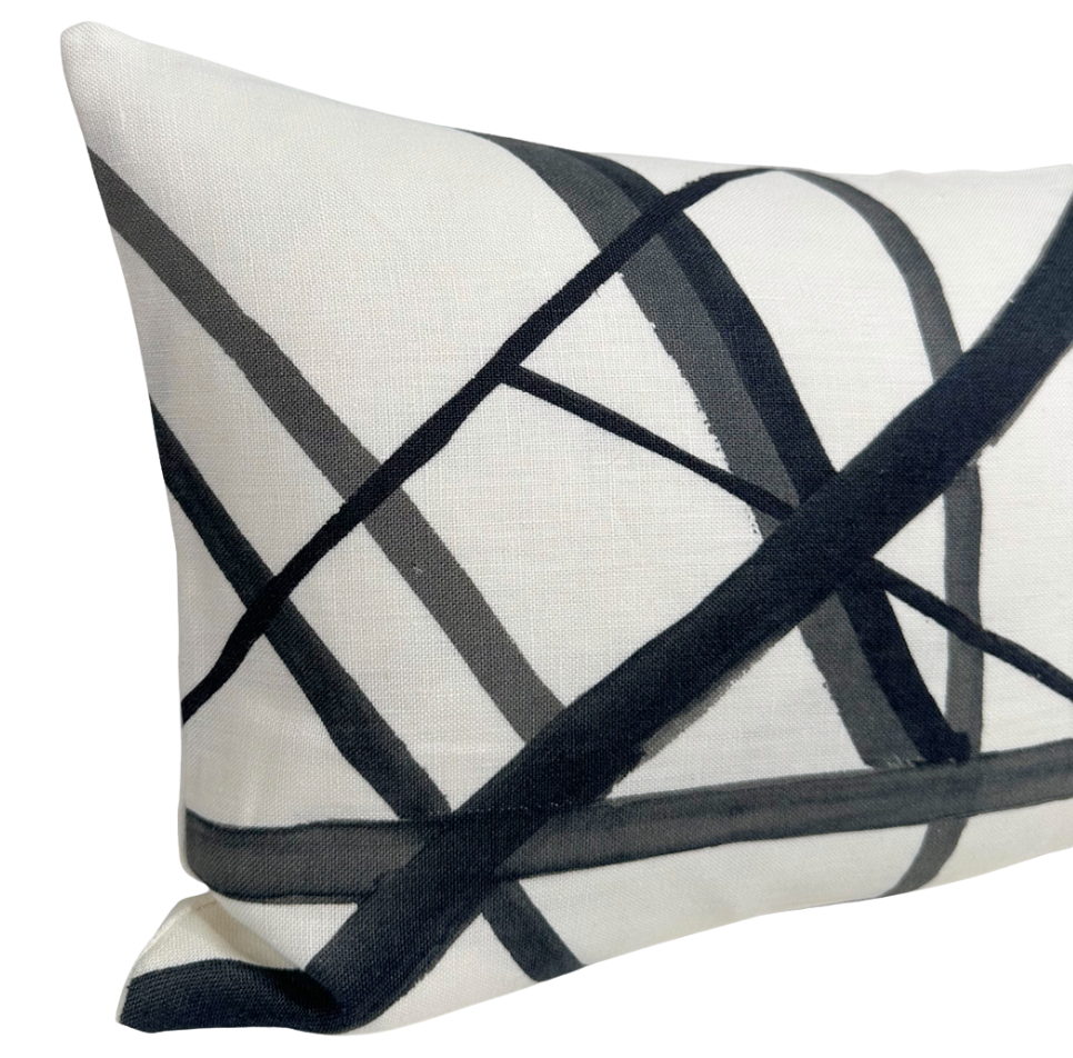 Rectangular white pillow with an abstract pattern of intersecting black and gray inspired brushstroke lines creating a geometric design.