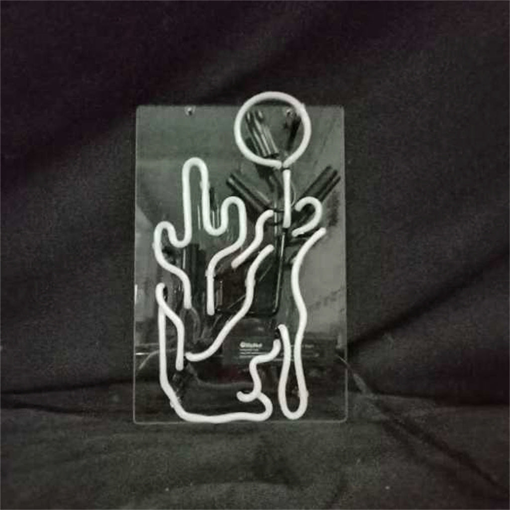 Clear rectangular panel with white neon tubing shaped like a cactus and a glowing circle above it, set against a dark background.