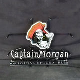 Neon sign featuring a stylized Captain Morgan pirate with red hat and white face, above white neon text reading 'Captain Morgan' and a black panel labeled 'Original Spiced Rum'.