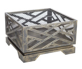 Square metal fire pit with intersecting geometric cutout patterns and mesh panels in an antique bronze finish, elevated on four short legs.