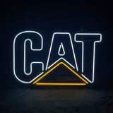 Neon sign displaying the word 'CAT' with white letters and a yellow triangle beneath the 'A' on a black background